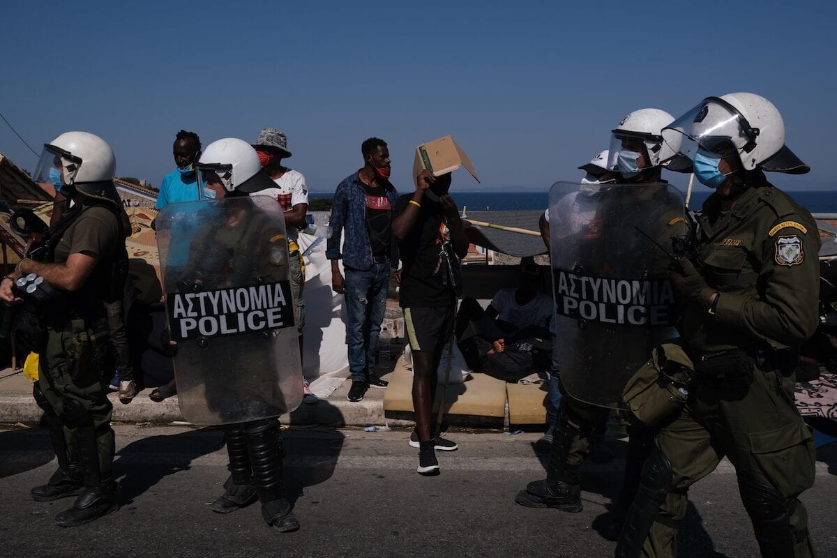 Police officers stand during the protest against the living conditions in the Moria refugee camp on the Greek island of Lesbos in Greece on September 11, 2020 [Aggelos Barai - Anadolu Agency]