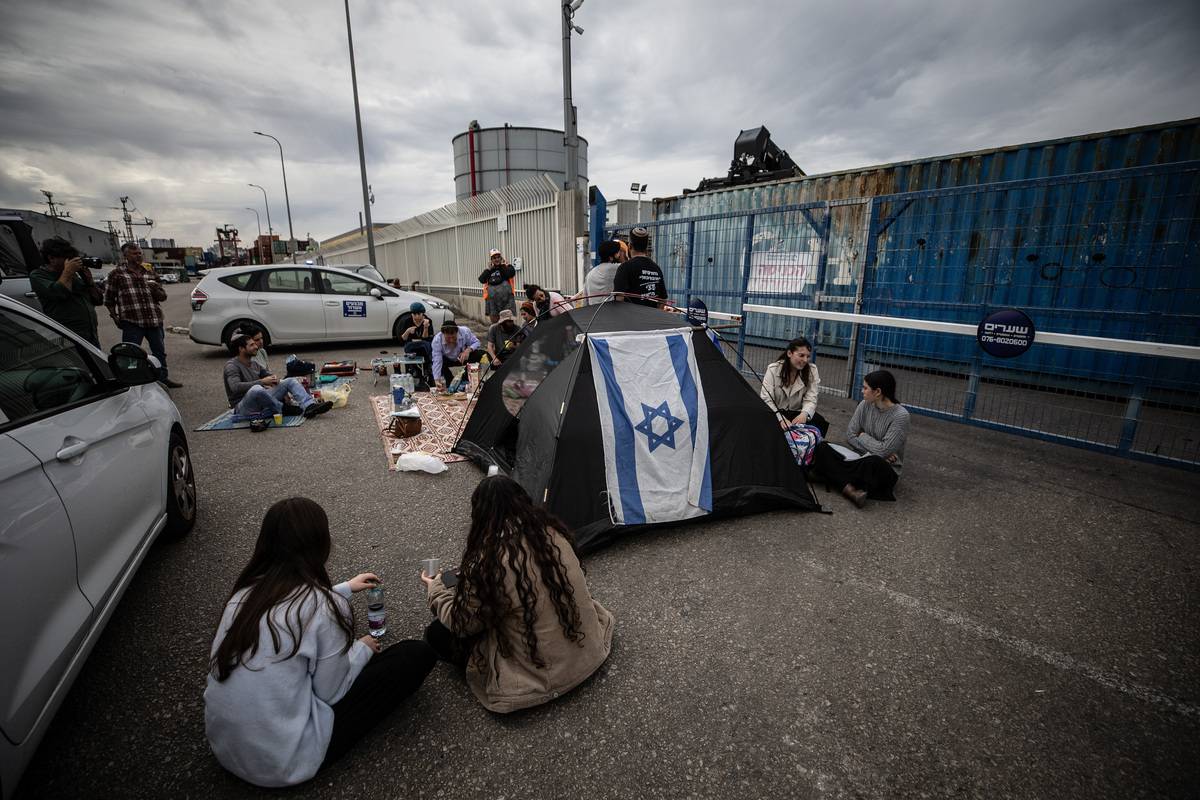 Activist Jewish settler group sits on the ground as they gather at the exit of Ashdod Port to prevent humanitarian aid, sent to Gaza, in Ashdod, Israel on February 13, 2024. [Mostafa Alkharouf - Anadolu Agency]